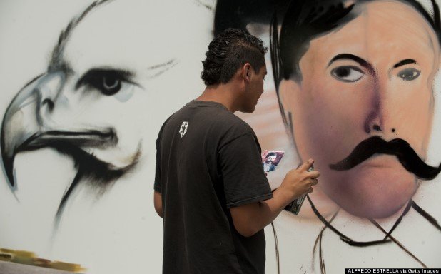 An artist works on his graffiti painting