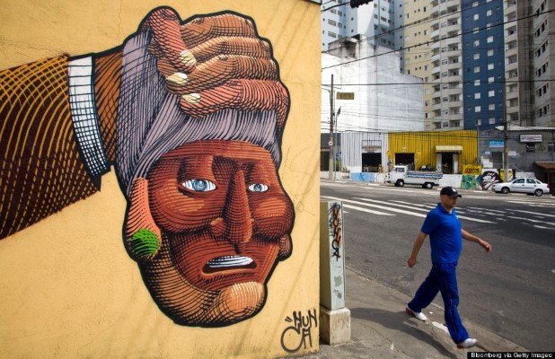 A pedestrian walks near a painted mural by Francisco Rodrigues da Silva, known as Nunca, in the Liberdade neighborhood of Sao Paulo, Brazil, on Thursday, Aug. 7, 2008. One month after Otavio and Gustavo Pandolfo painted the river facade of London's Tate Gallery for an exhibition of street art, their hometown took gray paint to one of their 680-meter long murals to comply with a law that aims to clean up the city. Following an outcry from graffiti artists -- including the Pandolfo brothers, who are internationally recognized by the moniker "Os Gemeos," or "the twins" -- the city government is rushing to register works of graffiti art that it will preserve. 