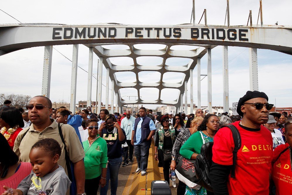 Thousands of people march across the Edmund Pettus Bridge during the 50th anniversary of the civil rights march in Selma, Alabama – March 8, 2015.