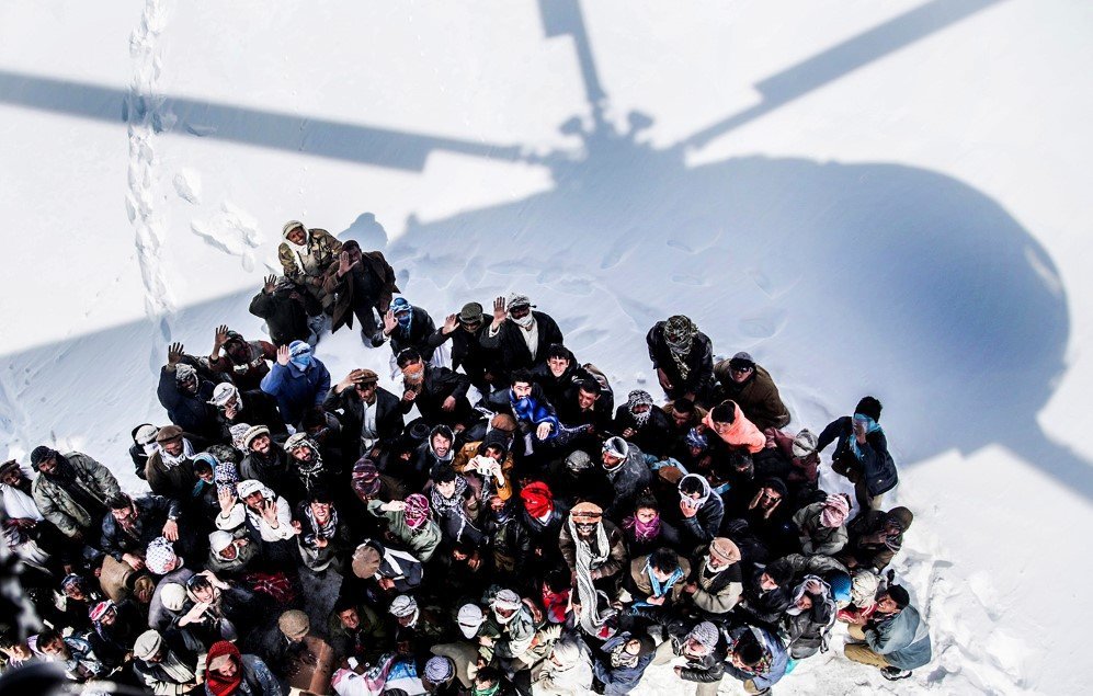 Survivors of an avalanche looking up to an army helicopter for relief goods in Paryan district of Panjshir province, Afghanistan – Feb. 28, 2015