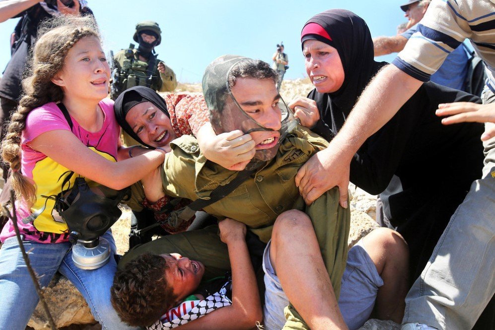 Palestinians fight to free a Palestinian boy held by an Israeli soldier during clashes between Israeli security forces and Palestinian protesters – Aug. 28,2015