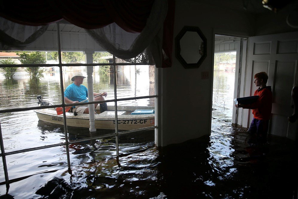 A man and a boy trying to move the left-over stuff during the record flooding in South Carolina – Oct. 9, 2015.